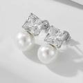 Macro shot of S925 silver stud earrings featuring square zircon and white pearl details - 925 Silver / Silver