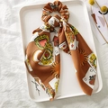 Brown satin scrunchie with playing card prints and ribbon tie on white tray - Coffee Poker