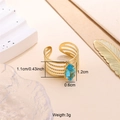Detail shot of a layered gold open ring featuring a blue marquise-cut zircon gemstone - Sky Blue