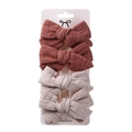 Close-up of four-piece bow hair clip set in beige and terracotta on display card - Brick Red & Beige