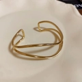 Minimalist double-layered wavy open arm cuff in a polished golden metallic finish - Gold Double Layer Streamline Wave Style