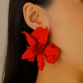 Close-up of a model wearing large matte red 3D floral earrings for party outfits - Red