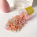 Bunte kleine elastische Haargummis für Mädchen fließen aus einem Klarsichtglas heraus - Dicke Creme Rosa Serie (ca. 500 Stück)