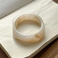 Detail of marble pattern resin bangle with brown swirl texture on an open book - Milky White Rhombus (Inner Diameter 65mm)