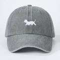 Detail van een grijze gewassen denim baseballpet met een witte geborduurde puppy - Eén maat / Grijs