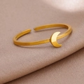 Primer plano de un anillo dorado con luna creciente sobre un fondo de seda elegante - Luna Dorada