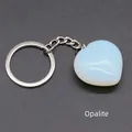 Heart-shaped synthetic opalite keychain with silver ring on a dark textured background - Opalite (Synthetic)