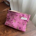 Pink floral embroidery makeup bag with purple and green patterns on a wooden table - Rose Red Rose