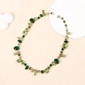 Collana geometrica dorata con pietre preziose verdi su una base minimalista chic - Collana