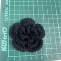 Detailed top view of 7cm black hand-crocheted 3-layer flower on a green cutting mat - 7cm / Black