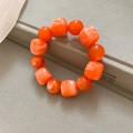 Gros plan d'un bracelet en perles acryliques orange aux formes irrégulières - Orange