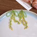 Macro detail of handmade green and yellow beaded tassel earrings on a white ceramic tray - 17# Silver Needle-Green-Bow