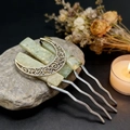 Macro view of crystal hair comb with crescent moon detail on a natural stone base - Prehnite