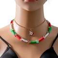 Close-up van gelaagde kerstketting met kerstmanhangers en gekleurde kralen op een model - Kerstman