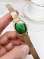 Close-up of retro gold mesh strap watch with a green oval dial on a wrist - Gold Band Green Dial