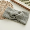 Detail of light grey knitted headband featuring a cross-knot design and wool texture - Gray