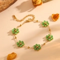 Detail of a gold bracelet with five green flower beads and an adjustable link chain - Gold Green Cat's Eye Bracelet