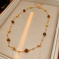 Close-up of gold-plated tiger eye beaded necklace with adjustable heart charm and chain - Necklace - Coffee (Gold Plated)