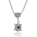 Macro shot of a silver turtle pendant featuring a blue evil eye on a box chain necklace - Turtle