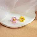Asymmetric daisy earrings in pink and yellow finish on a minimalist white tray - Pink and Yellow