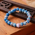 Detail of beaded bracelet with turquoise stones and white baseball-style accent bead - Blue Red White Spotted Baseball Wood Bracelet
