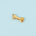 Macro shot of gold dog bone pendant with orange zircon inlay on light blue background - Gold Color November