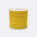 Detailed view of 0.8mm yellow braided cord on a white spool for jewelry making - Color 543 Ginger