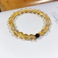 Detailaufnahme von Natur-Citrin und Granat Blumenarmband auf einem weißen Buch - 8 mm Perlendurchmesser (Inklusive Exquisiter Geschenkbox)
