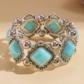 Close-up of bohemian stretch bracelet with turquoise rhombus stones and vintage engraving - Blue