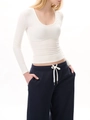 Detail of white slim fit U-neck long sleeve top paired with blue drawstring sweatpants - XS / White