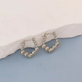 Detailed macro view of silver beaded hoop earrings on a textured stone display - Silver Beaded Hoop