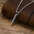 Collar con colgante de clavo en acero de titanio plateado sobre cuaderno de cuero - Color Acero