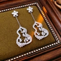 Nahaufnahme von silbernen Zirkonia-Ohrringen in Kürbisform mit Blumenmotiven - Silber