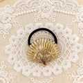 Minimalist gold shell hair tie with small starfish accents and black elastic band - Gold Starfish Shell