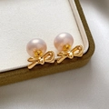 Vista de macro de pendientes de perlas y lazos bañados en oro de 18K en caja de lujo - Dorado con Perla Blanca Rosada