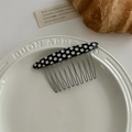 Detail of black hair side comb with white polka dots and silver metal teeth on a plate - Black And White Spots
