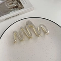 Elegante molletta per capelli dorata a onde con strass brillanti su un piatto decorato - Modello con Strass Dorati