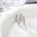 Detailed view of silver hoop earrings with triple-row pavé-set white zircons on white ceramic - 17x17mm / Silver