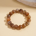 Detailed view of geometric acrylic beaded bracelet with brown marbled amber texture - Gray