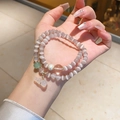 Detail of layered purple cat eye stone bracelet with pearl and gourd charm on wrist - Natural Cat's Eye Stone Freshwater Pearl Gourd Pendant Style