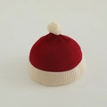 Close-up of contrast knit hat featuring dark red ribbed texture and beige pompom detail - 50-52cm (2-4 Years) / Wine Red & Beige
