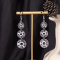 Detailed view of silver Bohemian tassel earrings with colorful enamel rings on a display stand - S4290-4 Black Enamel Mixed Triple Ring Earrings