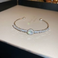 Detalle de brazalete abierto plateado con circón redondo central y pavé de diamantes - Pulsera Geométrica de Circón Plateado