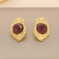 Macro detail of 18K gold-plated earrings with irregular hammered texture and red opal stones - Gold Purple Style (KE116412)