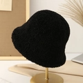Detail of plush black teddy fleece bucket hat on an elegant minimalist display stand - Black