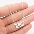 Macro detail of silver O-chain and gothic number 1988 pendant on a stainless steel necklace - 1988 / Steel