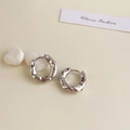 Detail of silver irregular lava earrings with high polish texture on white stone - Rhodium Plated Silver Textured Hoop