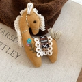 Macro shot of handmade yellow fabric horse brooch with floral embroidery and lace details - Ginger (Embroidered Style)