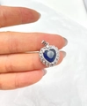 Detail of a dark blue heart-shaped gemstone pendant surrounded by white crystals in silver - Silver Tone + Royal Blue