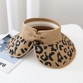 Detail of straw sun visor featuring leopard print brim and woven bow decoration - One Size / Brown